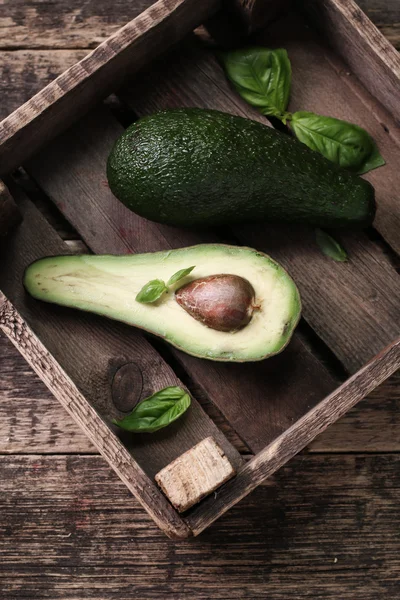 Lebensmittelhintergrund mit frischer Bio-Avocado auf altem Holztisch, Draufsicht, Kopierraum — Stockfoto