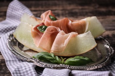 Prosciutto ve vintage ahşap zemin üzerine fesleğen taze kavun