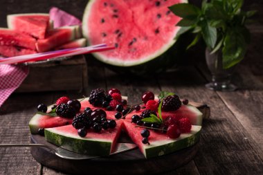 renkli tropikal meyve karpuz pizza kesimleri içine bir rustik ahşap tahta üzerinde kesme çilek ile tepesinde