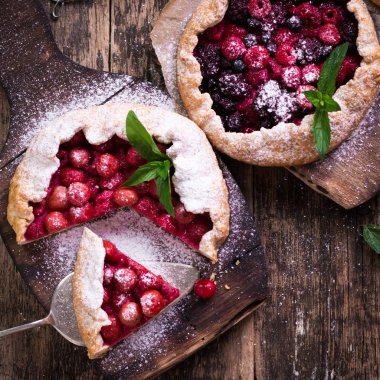 Yaban mersini, kiraz, ahududu ve blackcurrant Galette'ye w ahşap zemin üzerine.