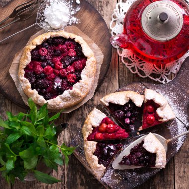 Yaban mersini, kiraz, ahududu ve blackcurrant Galette'ye w ahşap zemin üzerine.