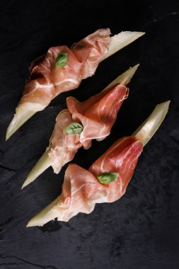 Prosciutto ve vintage ahşap zemin üzerine fesleğen taze kavun