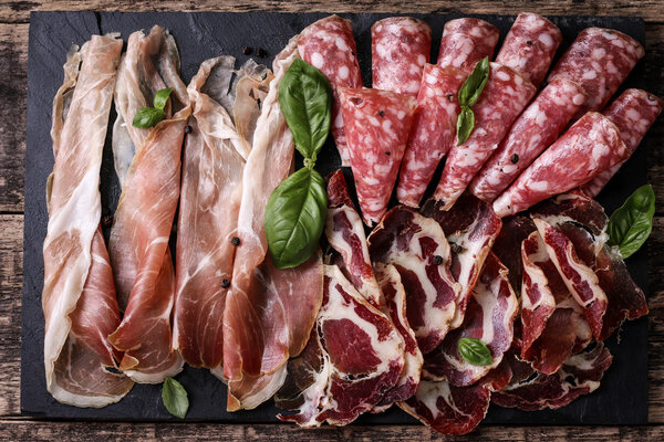 Traditional spanish tapas or italian antipasti on wooden vintage table