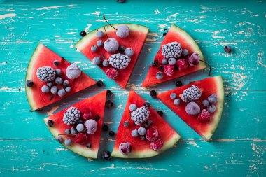 renkli tropikal meyve karpuz pizza kesimleri içine bir rustik ahşap tahta üzerinde kesme çilek ile tepesinde