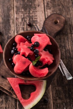 Karpuz ve çilek yaz meyve salatası. Bir yıldız, kalp, ay .tahta arka plan şeklinde karpuz dilimleri