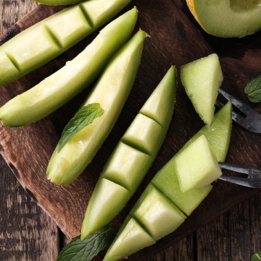 Dilimlenmiş taze kavun ve ahşap masa, sağlıklı gıda nane