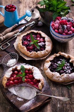 Yaban mersini, kiraz, ahududu ve blackcurrant Galette'ye w ahşap zemin üzerine.