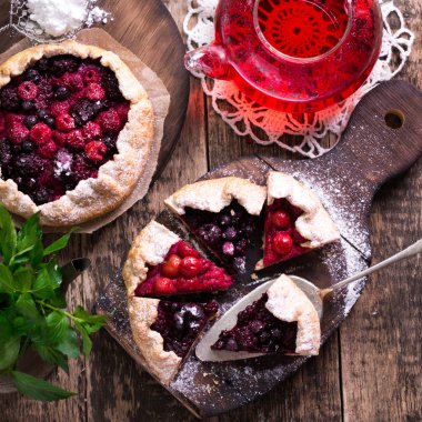Yaban mersini, kiraz, ahududu ve blackcurrant Galette'ye w ahşap zemin üzerine.