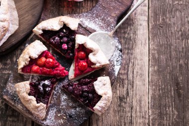 Yaban mersini, kiraz, ahududu ve blackcurrant Galette'ye w ahşap zemin üzerine.