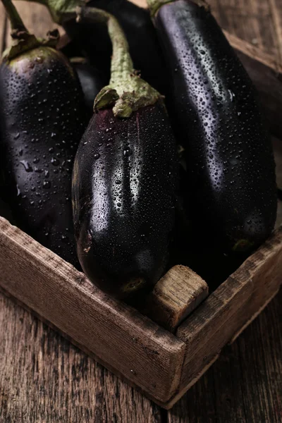 Frische Auberginen auf dunklem Holzgrund.. vegetarisches Essen — Stockfoto