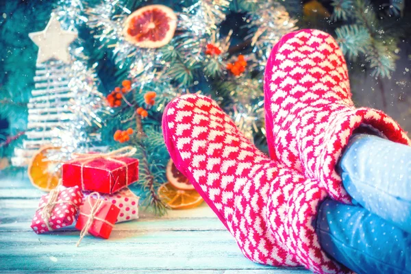 Woman relaxes her feet in woollen socks.Winter and Christmas holidays concept.