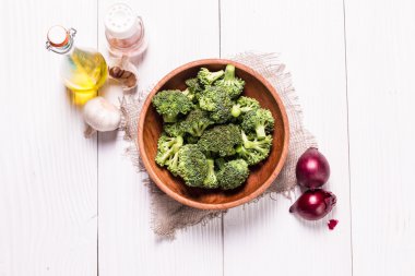 Kahverengi tabakta bir sürü taze yeşil brokoli, ahşap arka planda.