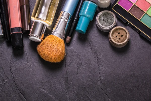 Various makeup products on dark background with copyspace — Stock Photo, Image