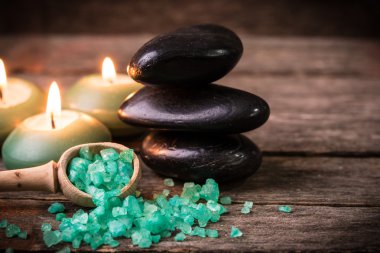 ahşap masa üzerinde taş ve mumlar ile spa konsepti ,