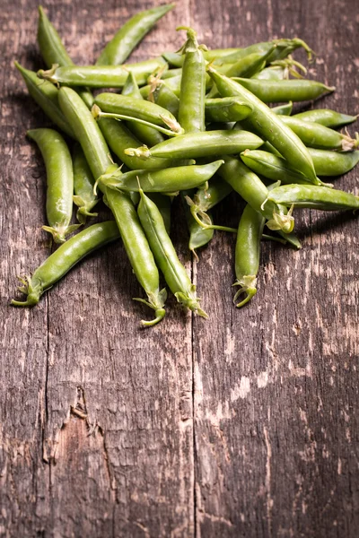 Guisantes verdes en mesa de madera, concepto saludable —  Fotos de Stock