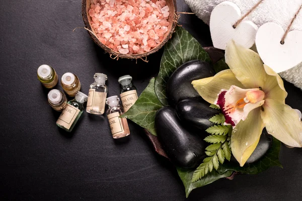 Concept spa avec pierres, fleurs, huiles essentielles et sel minéral sur table en bois — Photo