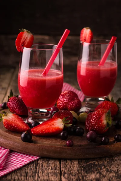 Vasos de batido frío fresco con frutas y bayas, sobre fondo de madera, bebida desintoxicante saludable —  Fotos de Stock