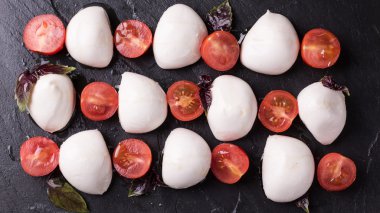 domates ve fesleğen kayrak tahta üzerinde mozzarella topları