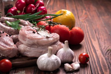 Taze kasap et ürün yelpazesine ahşap masa üzerinde taze biberiye ile süslenmiş kesmek
