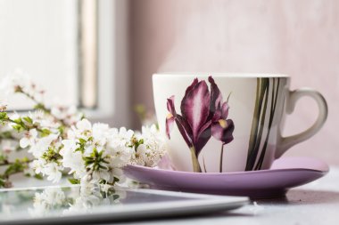 Pencere whith bahar çiçek yanında sıcak bir içecek Kupası