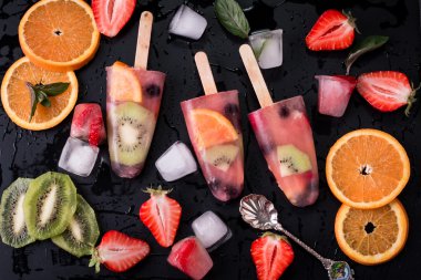 Ahşap antika masa üzerinde çilek Çilek kivi ile sağlıklı tüm meyve Popsicles