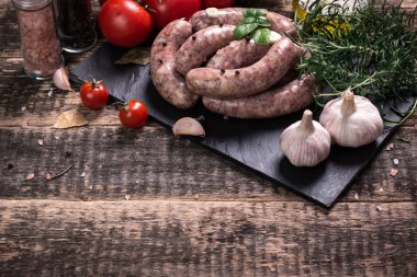 Taze kasap et ürün yelpazesine ahşap masa üzerinde taze biberiye ile süslenmiş kesmek