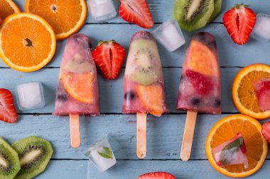 Ahşap antika masa üzerinde çilek Çilek kivi ile sağlıklı tüm meyve Popsicles