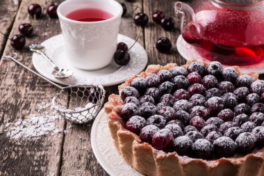 Ahşap antika masa üzerinde kiraz ve çırpılmış kremalı tart