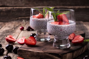 Chia tohum pudingi çilek ve ahşap antika arka plan üzerinde min