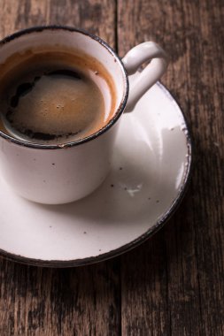 Kahve fincanı ve vintage ahşap zemin üzerine kahve çekirdekleri