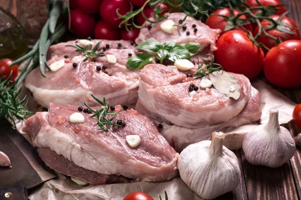 Carnicero fresco corte surtido de carne adornado con romero fresco en mesa de madera — Foto de Stock