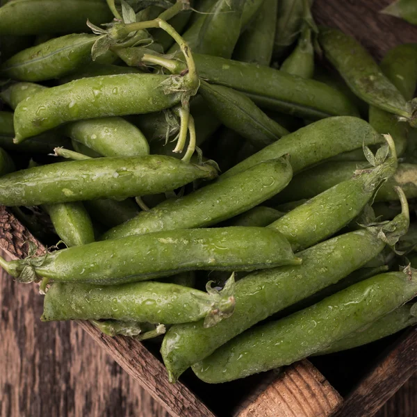 Vainas de guisantes verdes en una mesa de madera, estilo rústico, comida saludable —  Fotos de Stock