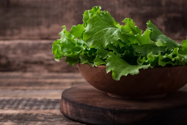 Feuilles de laitue sur table en bois, nourriture saine — Photo