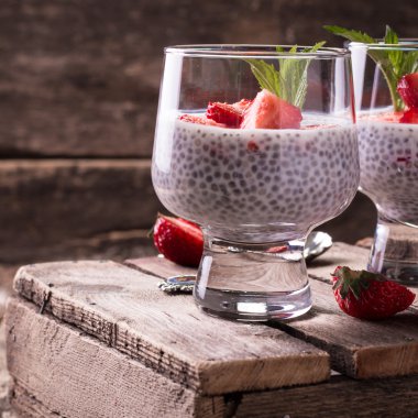 Chia tohum pudingi çilek ve ahşap antika arka plan üzerinde min