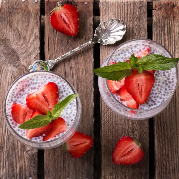 Chia tohum pudingi çilek ve ahşap antika arka plan üzerinde min