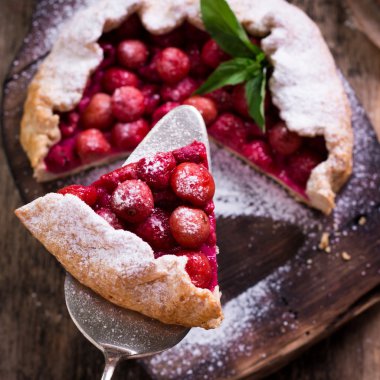 Yaban mersini, kiraz, ahududu ve blackcurrant Galette'ye w ahşap zemin üzerine.