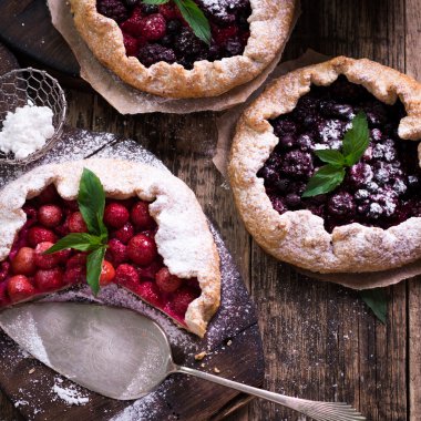 Yaban mersini, kiraz, ahududu ve blackcurrant Galette'ye w ahşap zemin üzerine.