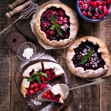 Yaban mersini, kiraz, ahududu ve blackcurrant Galette'ye w ahşap zemin üzerine.