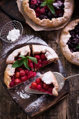 Yaban mersini, kiraz, ahududu ve blackcurrant Galette'ye w ahşap zemin üzerine.