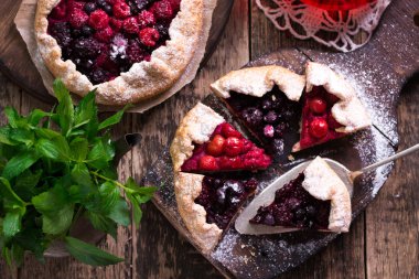 Yaban mersini, kiraz, ahududu ve blackcurrant Galette'ye w ahşap zemin üzerine.