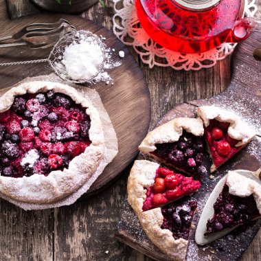 Yaban mersini, kiraz, ahududu ve blackcurrant Galette'ye w ahşap zemin üzerine.