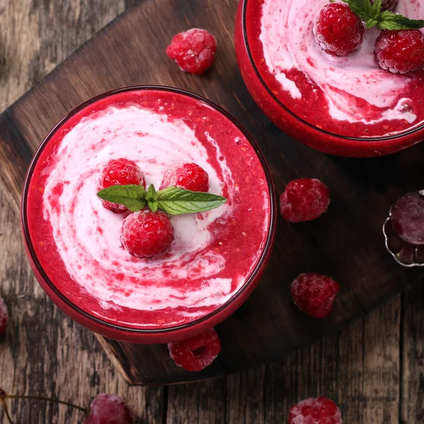 Rosa Himbeer-Smoothie mit Eis und Minze auf rustikalem Holzhintergrund — Stockfoto