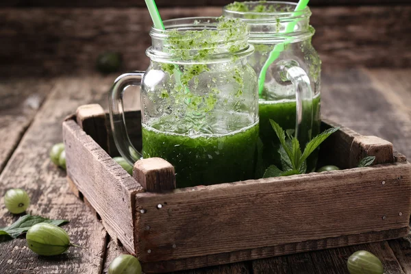 Smoothie hijau segar dengan sedotan di atas meja kayu, makanan vegetarian yang sehat — Stok Foto