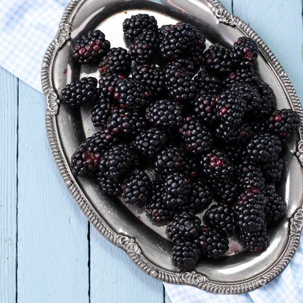 Ripe blackberries in a ceramic bowl on burlap cloth over wooden background close up. Rustic style, Selective focus Royalty Free Stock Photos