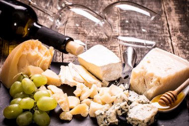 Kompozisyon peynir, çilek, şişe ve bardak şarap ahşap bir masa üzerinde 