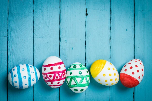 Conceito de Páscoa com ovos coloridos em fundo de madeira — Fotografia de Stock