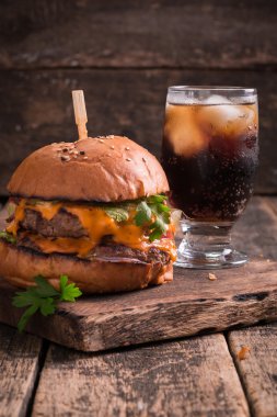 hamburger ya da çizburger ve meşrubat vintage ahşap masa üzerinde Fast food