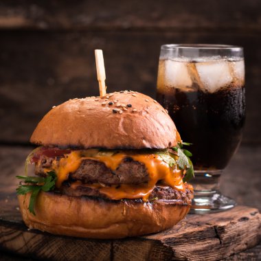 hamburger ya da çizburger ve meşrubat vintage ahşap masa üzerinde Fast food