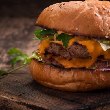 Lezzetli ızgara burger marul ve mayonez, rustik ahşap bir masa üzerinde