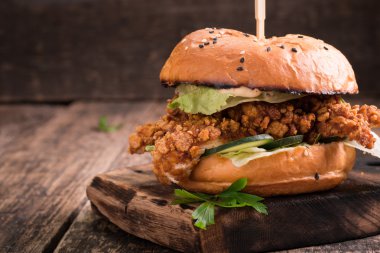 Lezzetli ızgara burger marul ve mayonez, rustik ahşap bir masa üzerinde